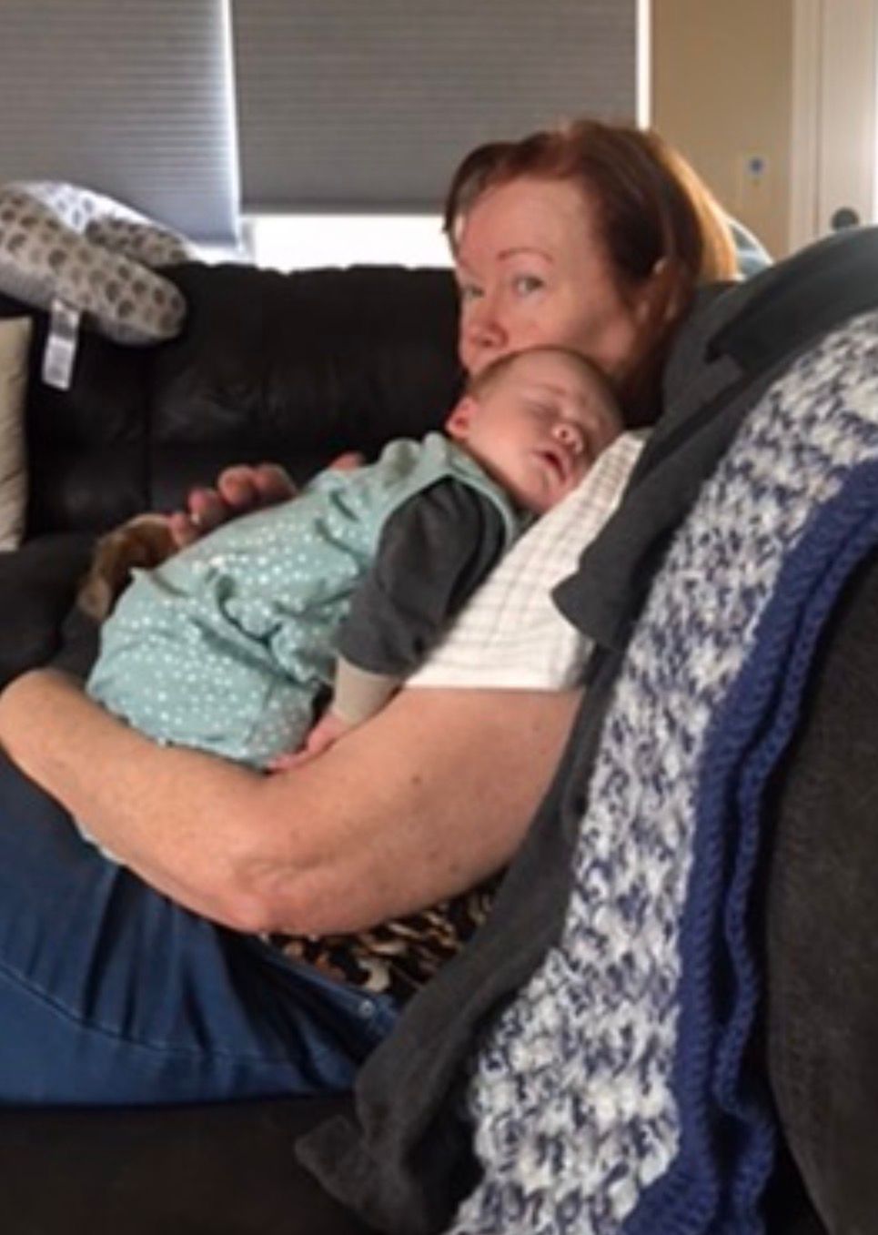 Sandy resting with a sleeping child in her arms