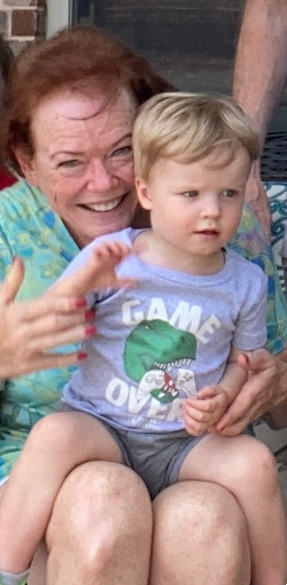 Sandy smiling with a young grandchild